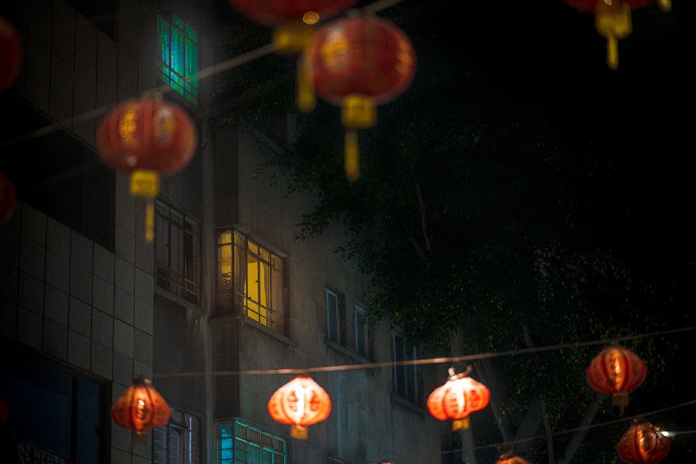 red lanterns hanging from a wire in front of a building