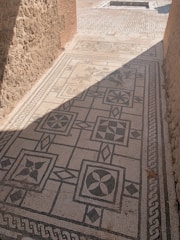 Close-up of a detailed mosaic floor with geometric shapes.