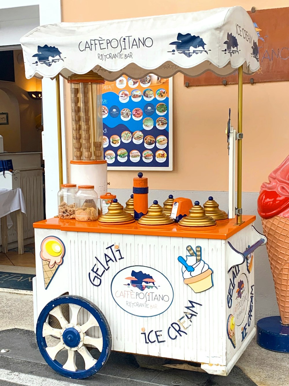 a small ice cream cart sitting on the side of a road