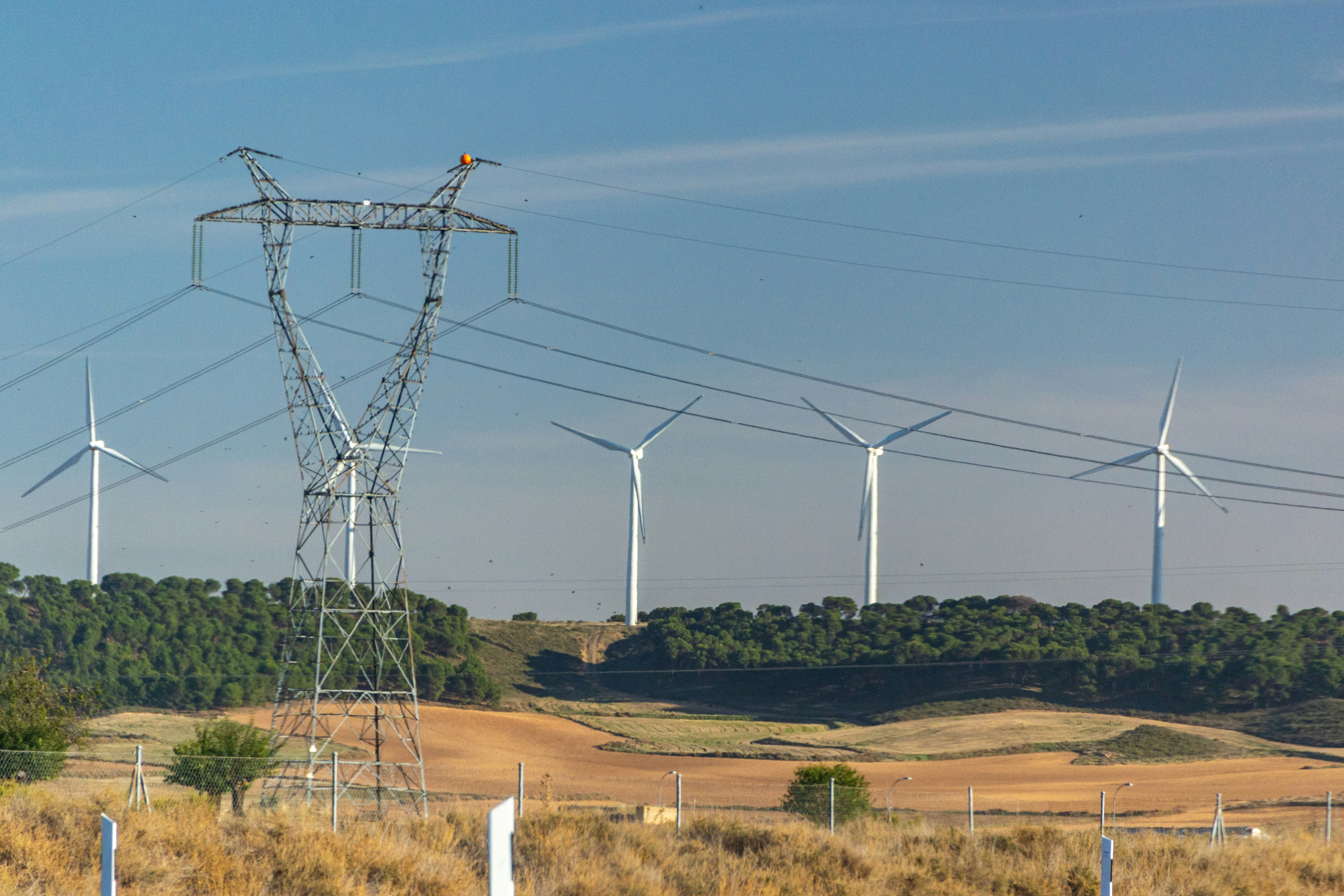 a wind farm with wind turbines in the background