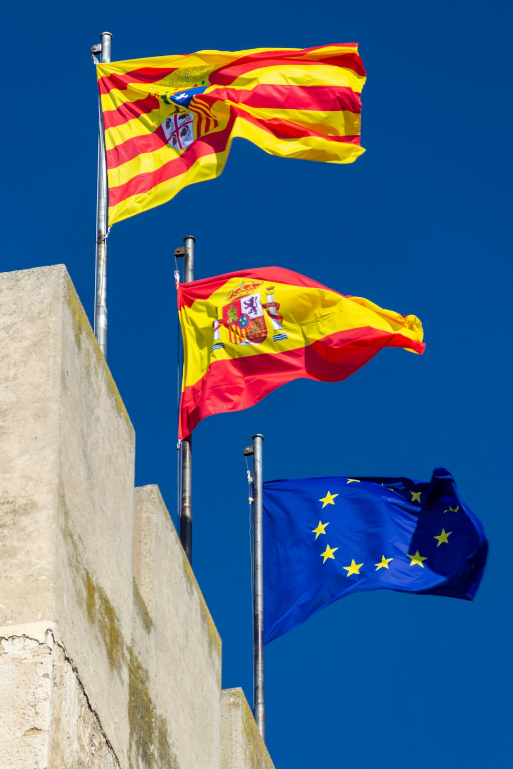 Tres banderas ondeando en el viento en un día soleado