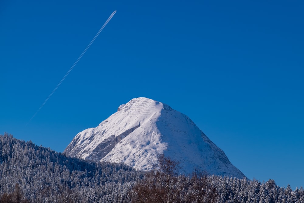 Ein Flugzeug fliegt über einen schneebedeckten Berg