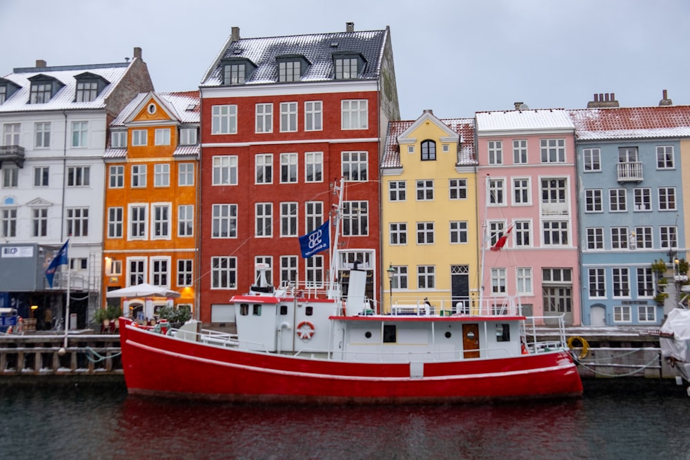 a red and white boat sitting in the water