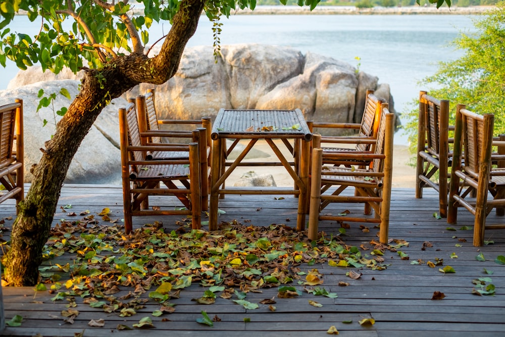 a table and chairs sitting on a deck next to a tree