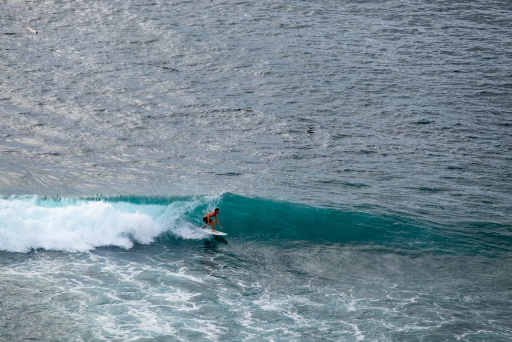 a man riding a wave on top of a surfboard