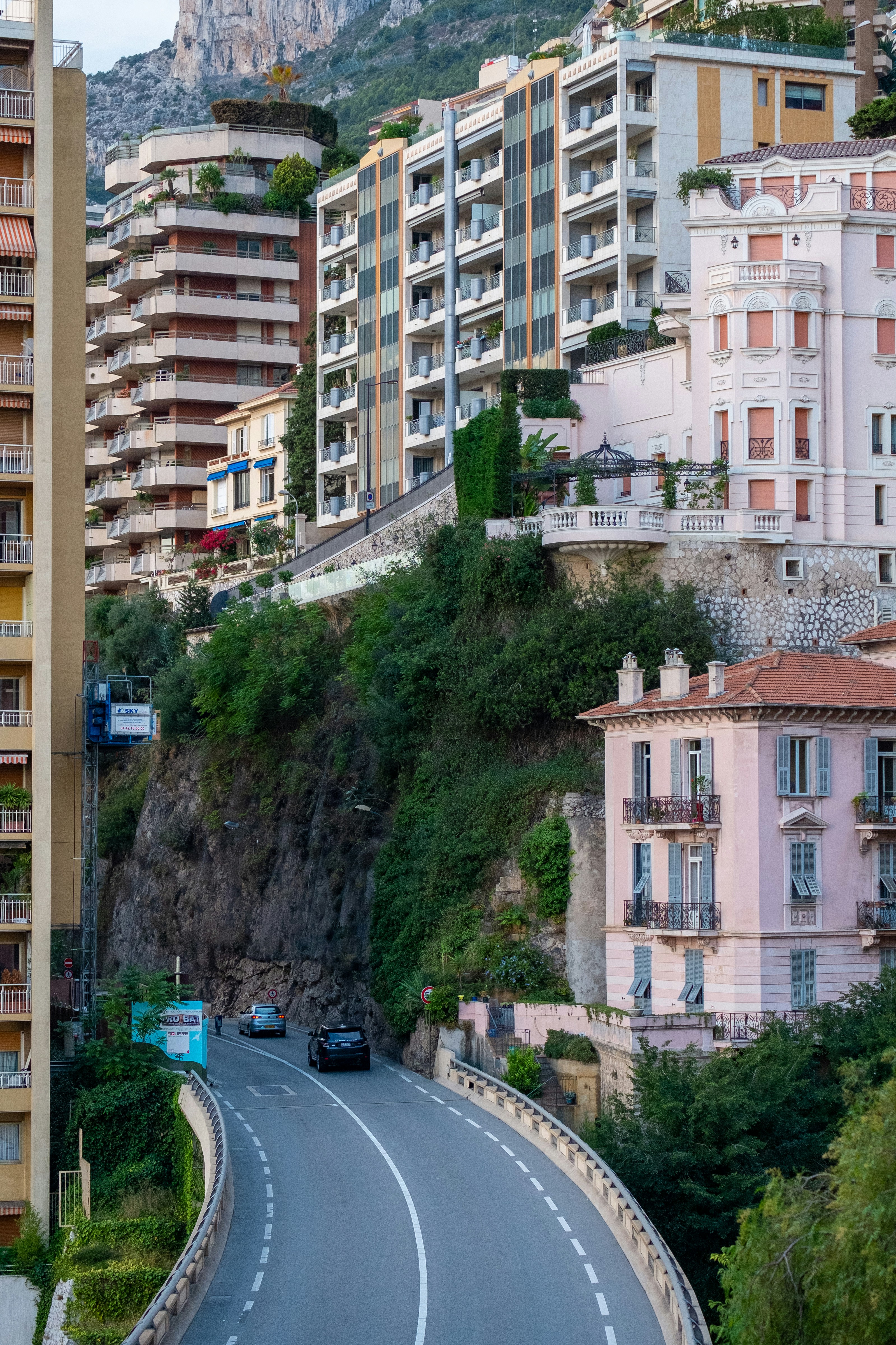 a street with cars driving down it next to tall buildings