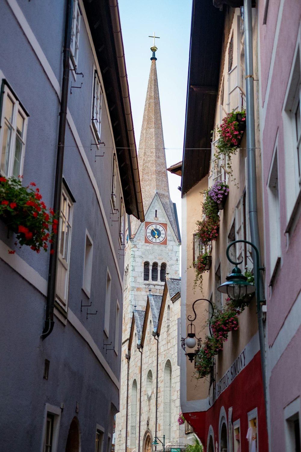 a narrow street with a church steeple in the background