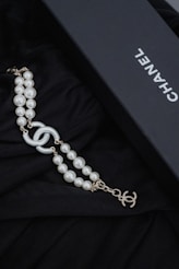 a black box with a necklace and pearls Chanel