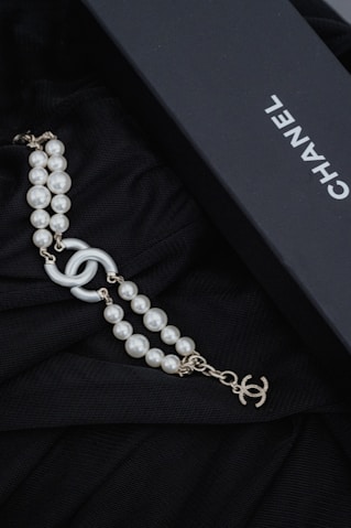 a black box with a necklace and pearls Chanel