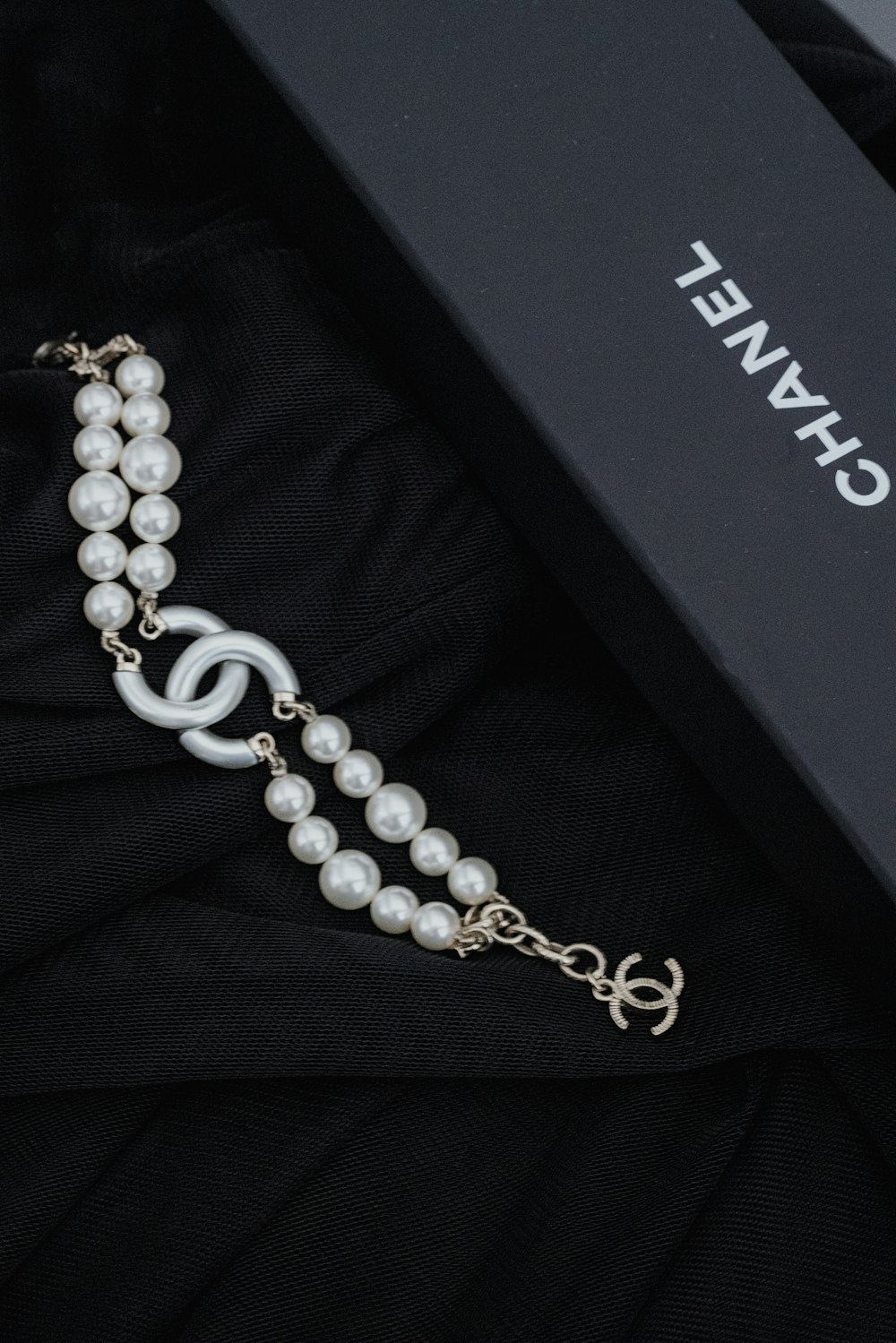 eine schwarze Box mit Halskette und Perlen