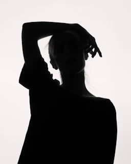 a black and white photo of a woman with her hands on her head
