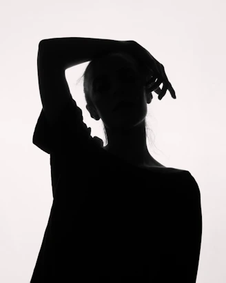 a black and white photo of a woman with her hands on her head
