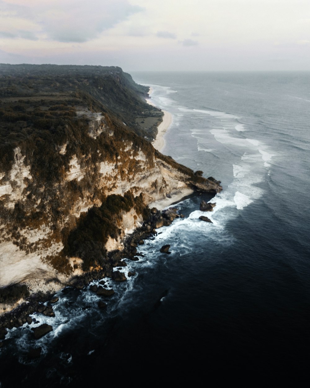 an aerial view of a beach near a cliff