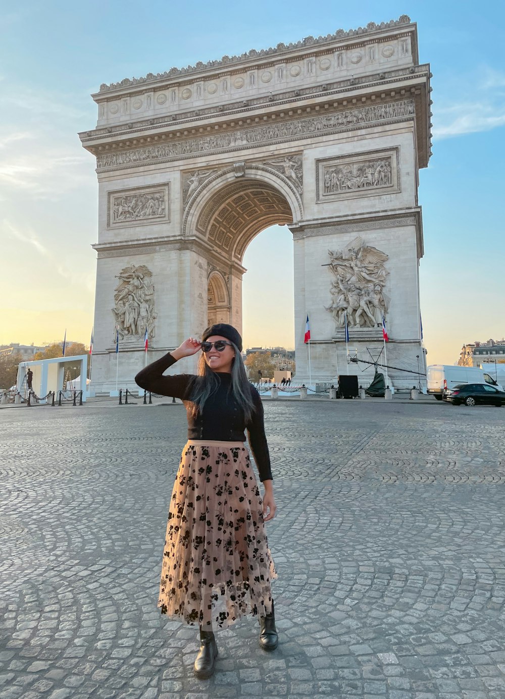 a woman standing in front of the arc of triumph