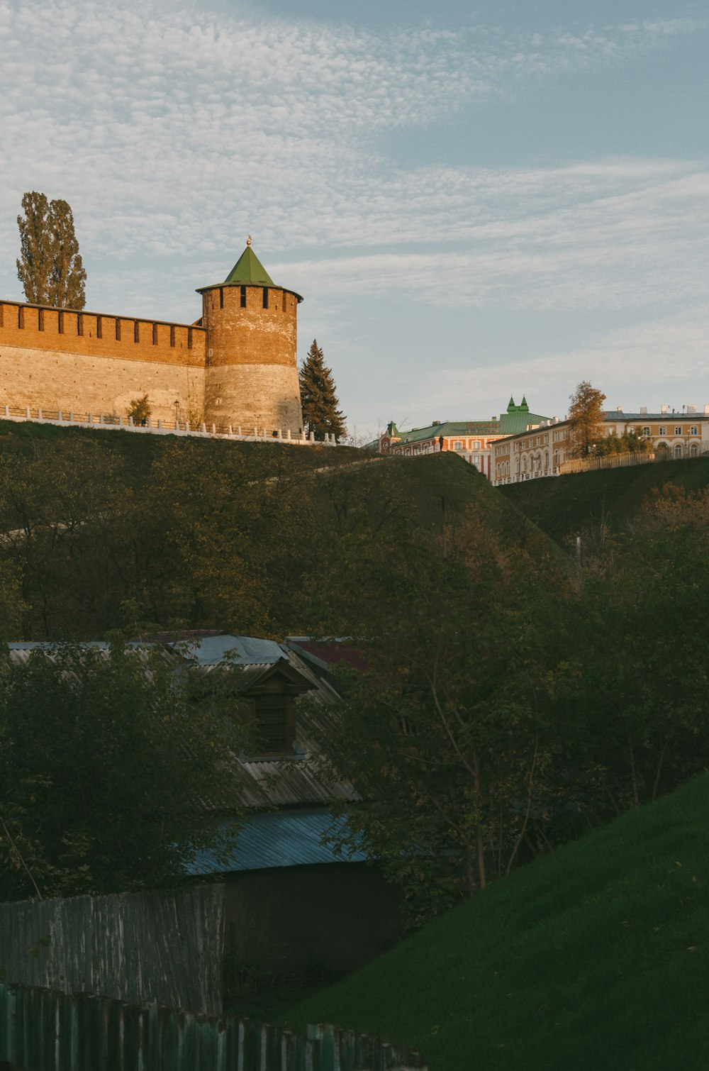 un château au sommet d’une colline entourée d’une clôture