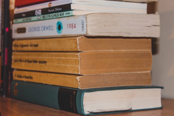 a stack of books sitting on top of a wooden table