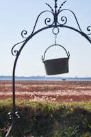 A sturdy water bucket filled at a rural well under a bright blue sky.