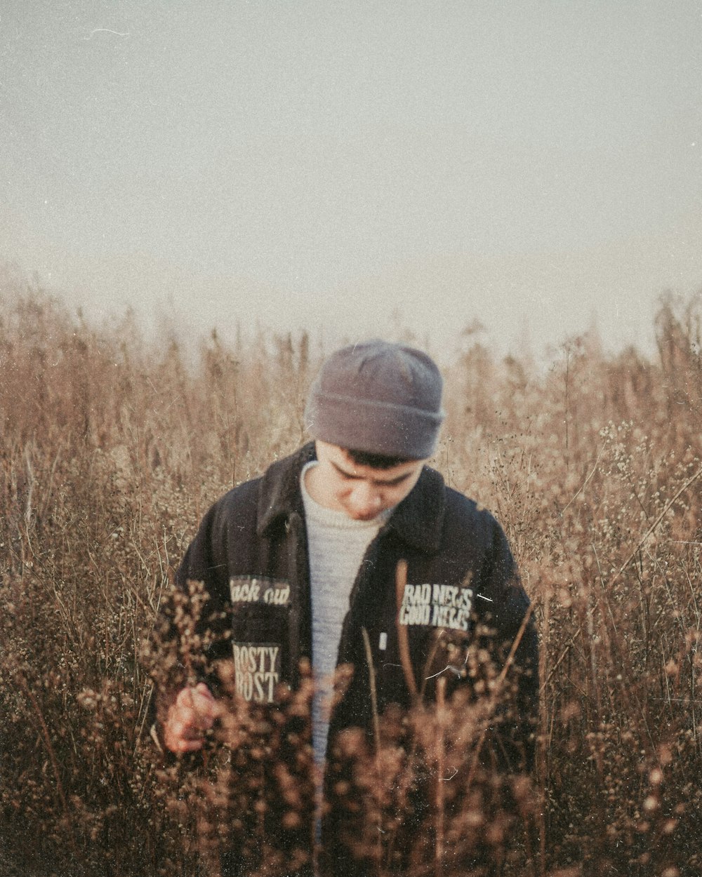 a man standing in a field of tall grass