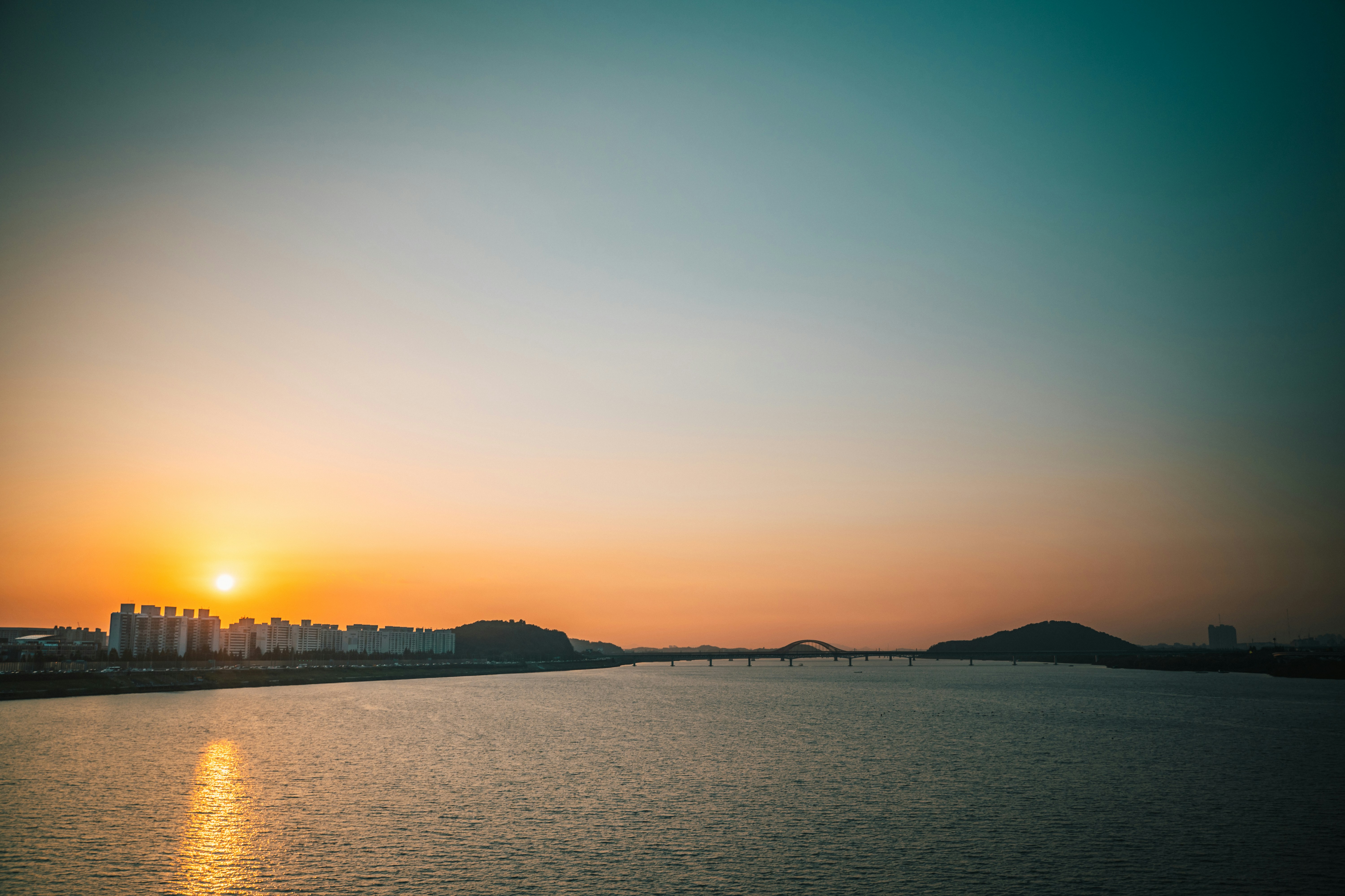 the sun is setting over a body of water