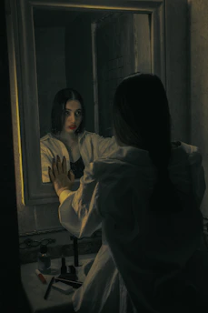 a woman standing in front of a mirror
