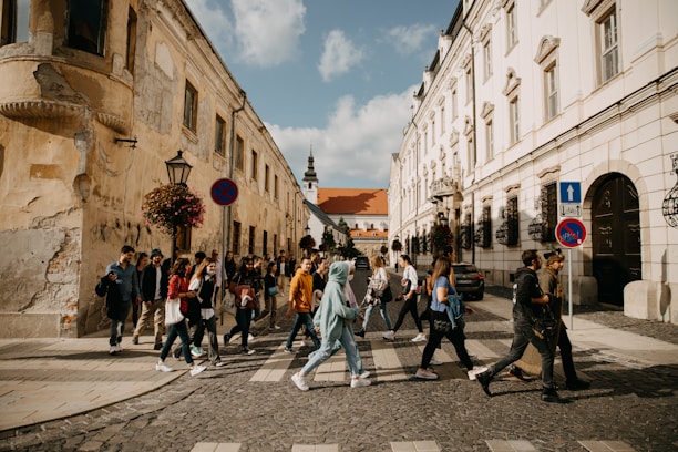 A diverse group of travelers happily exploring a European city with their travel documents in hand.
