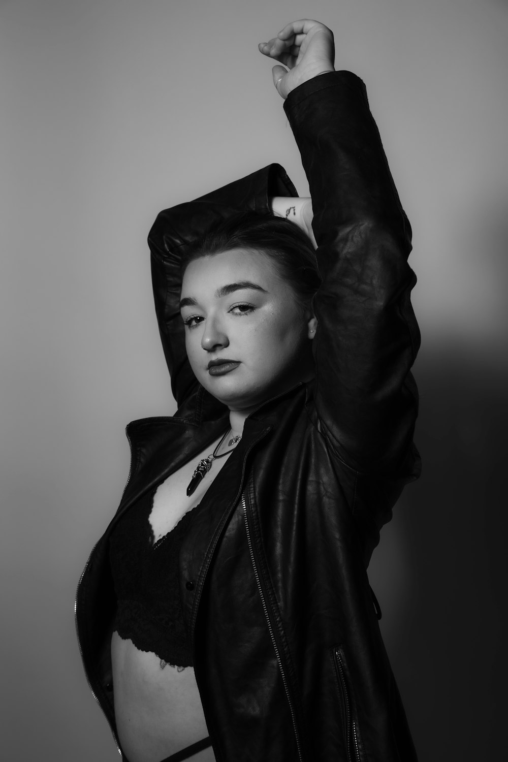 a woman in a leather jacket is posing for a picture