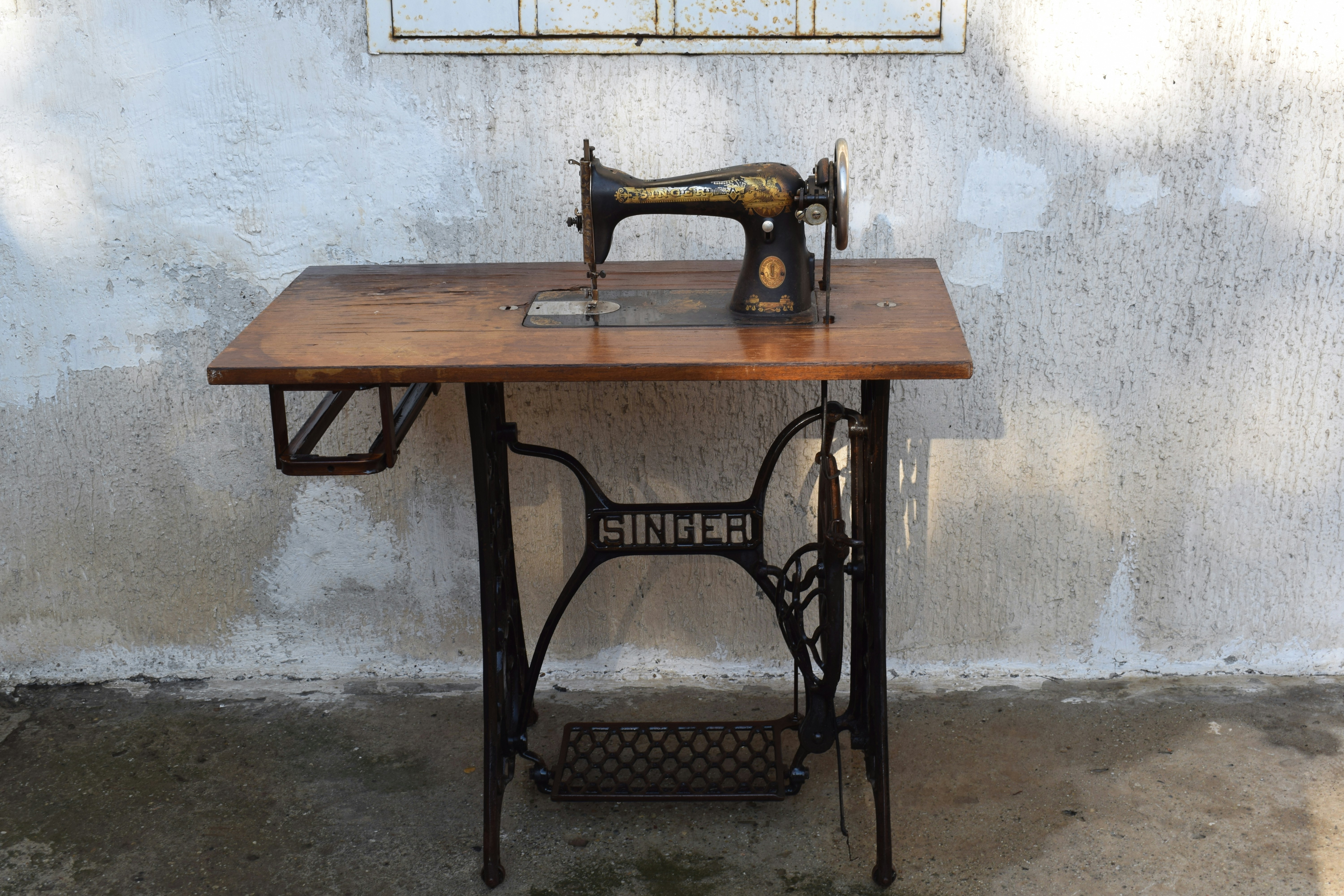 A sewing machine sitting on top of a wooden table photo – Free Grey ...
