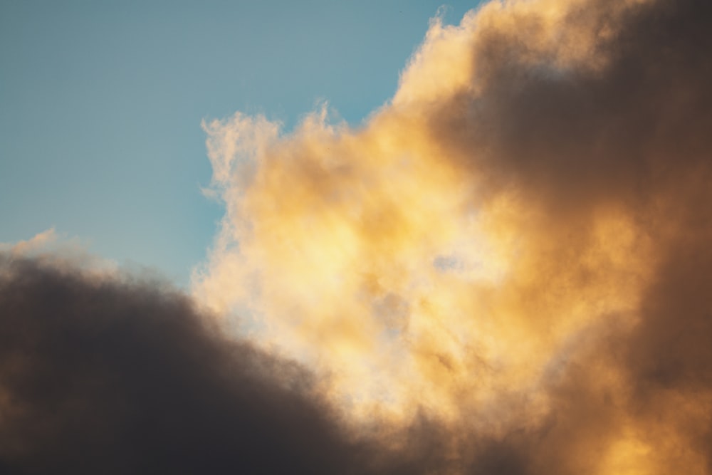 a plane flying through a cloudy blue sky