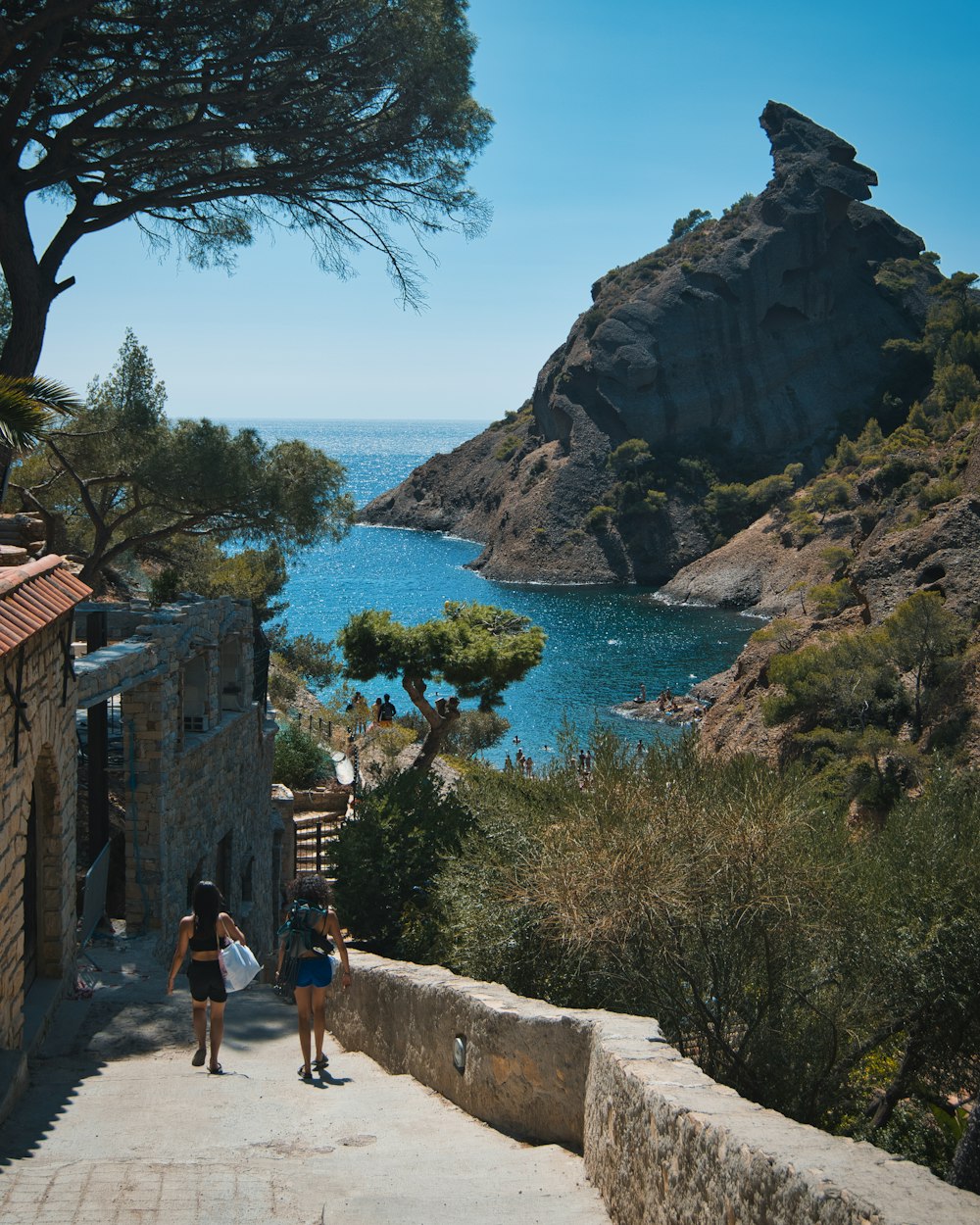 a couple of people walking down a stone walkway