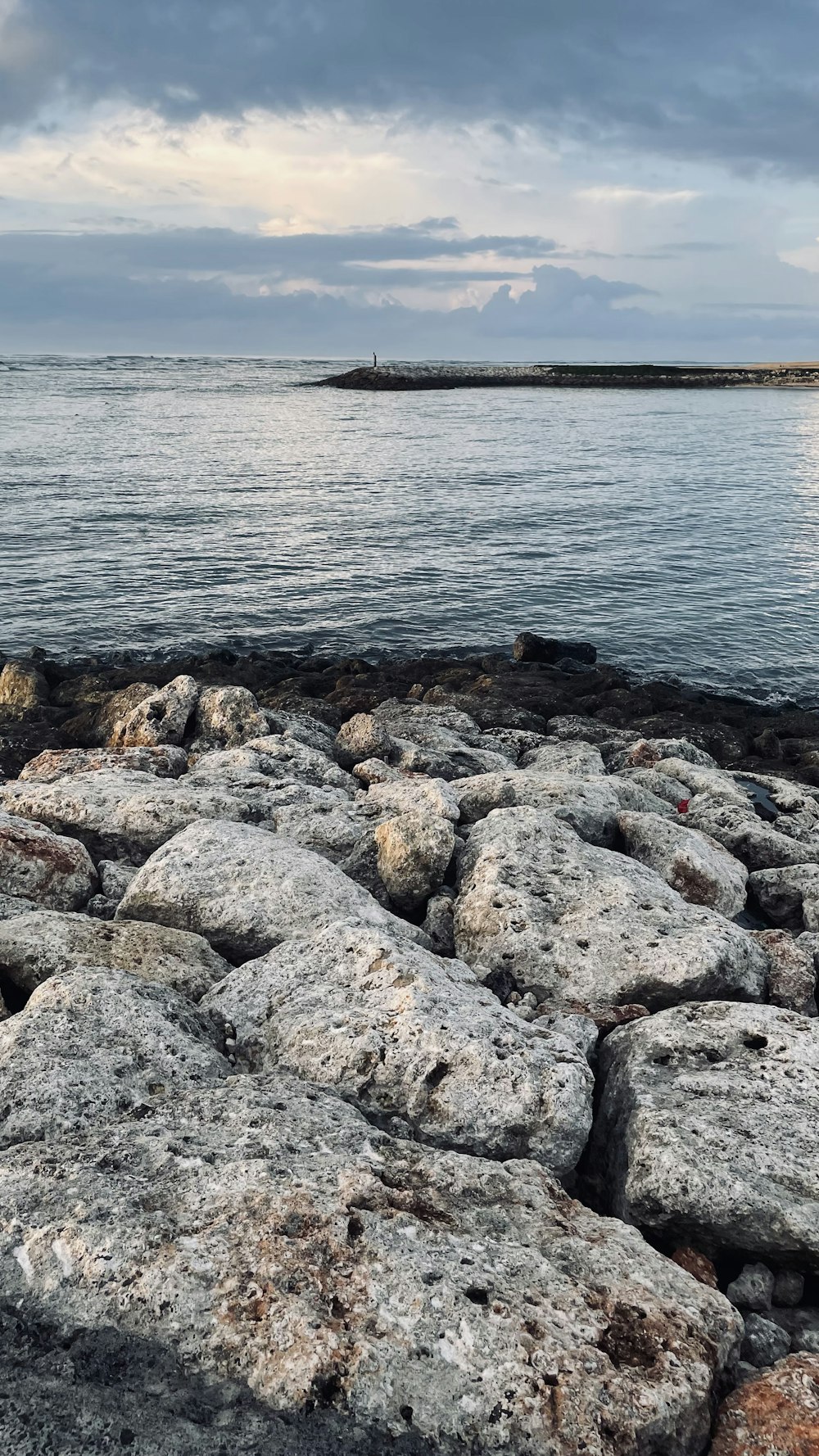 a large body of water sitting next to a rocky shore