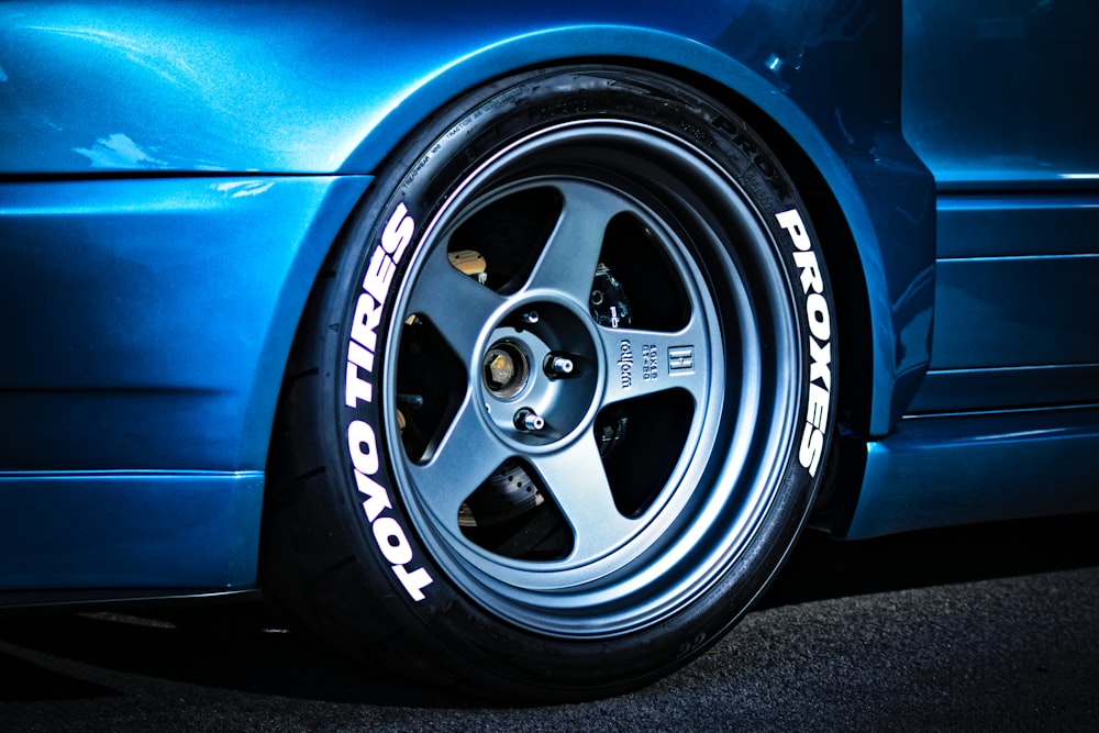 a close up of a tire on a blue sports car