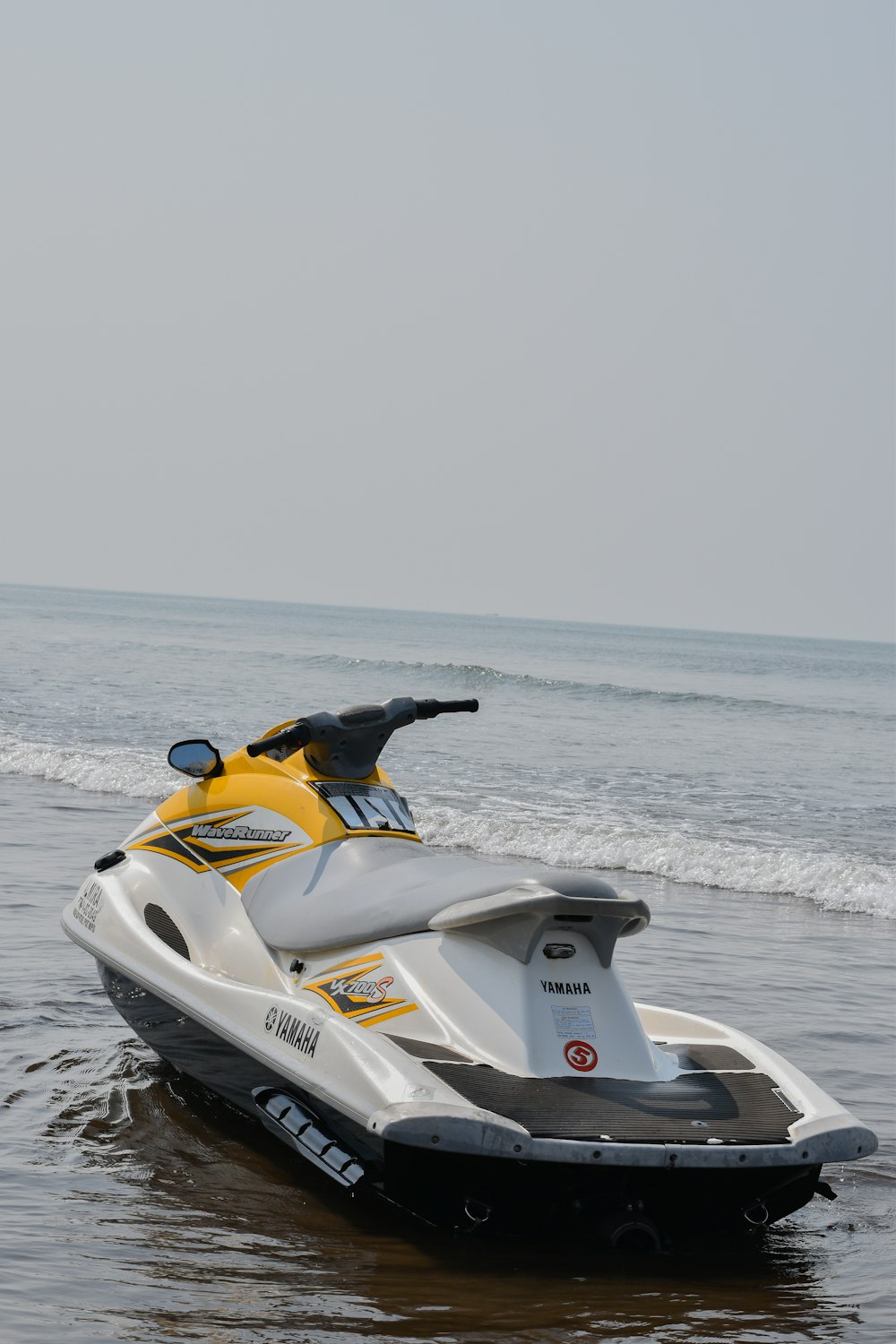 Una moto acuática amarilla y blanca está en el agua