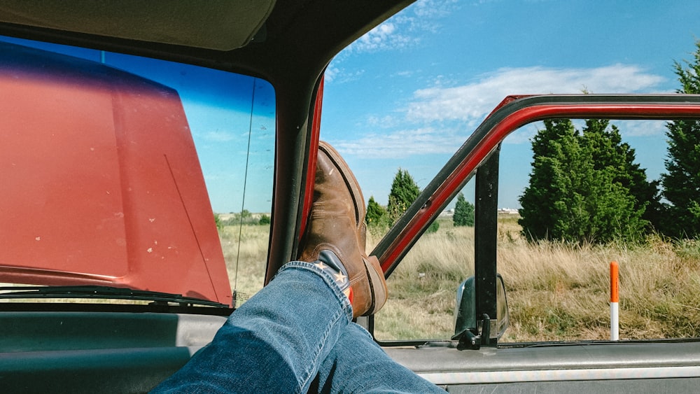 a person's feet sticking out the window of a vehicle