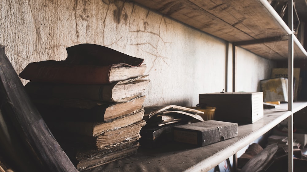 a stack of books sitting on top of a shelf