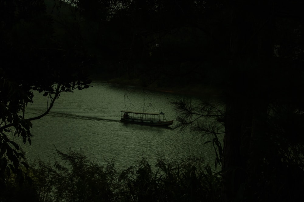 a boat floating on top of a lake at night