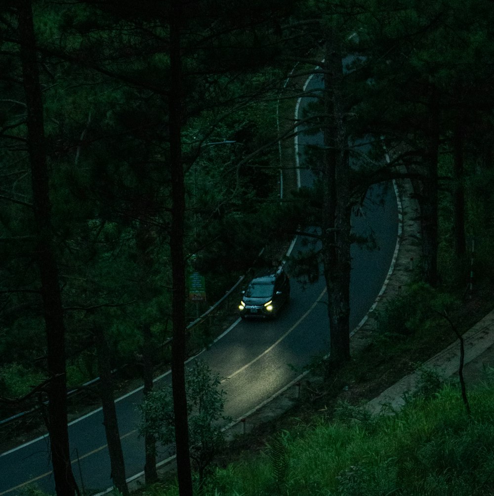 a car driving down a road in the dark