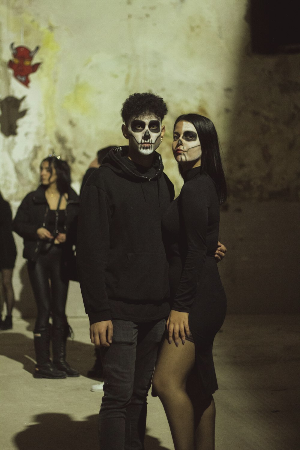 a man and a woman in skeleton makeup standing next to each other