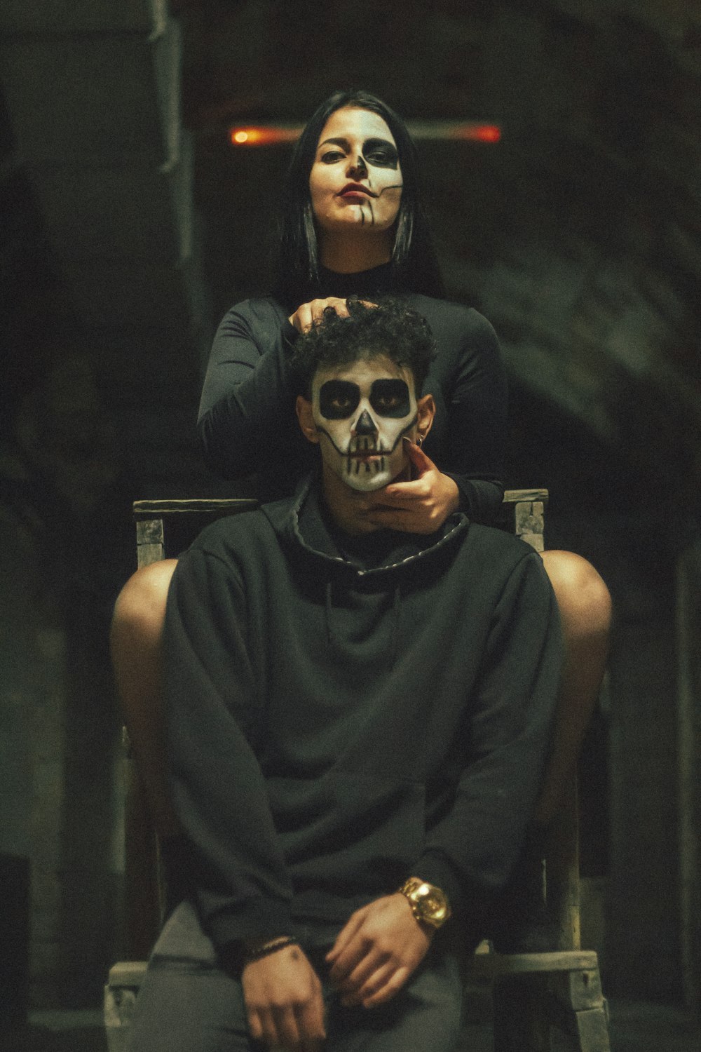 a man and a woman with face paint sitting in a chair