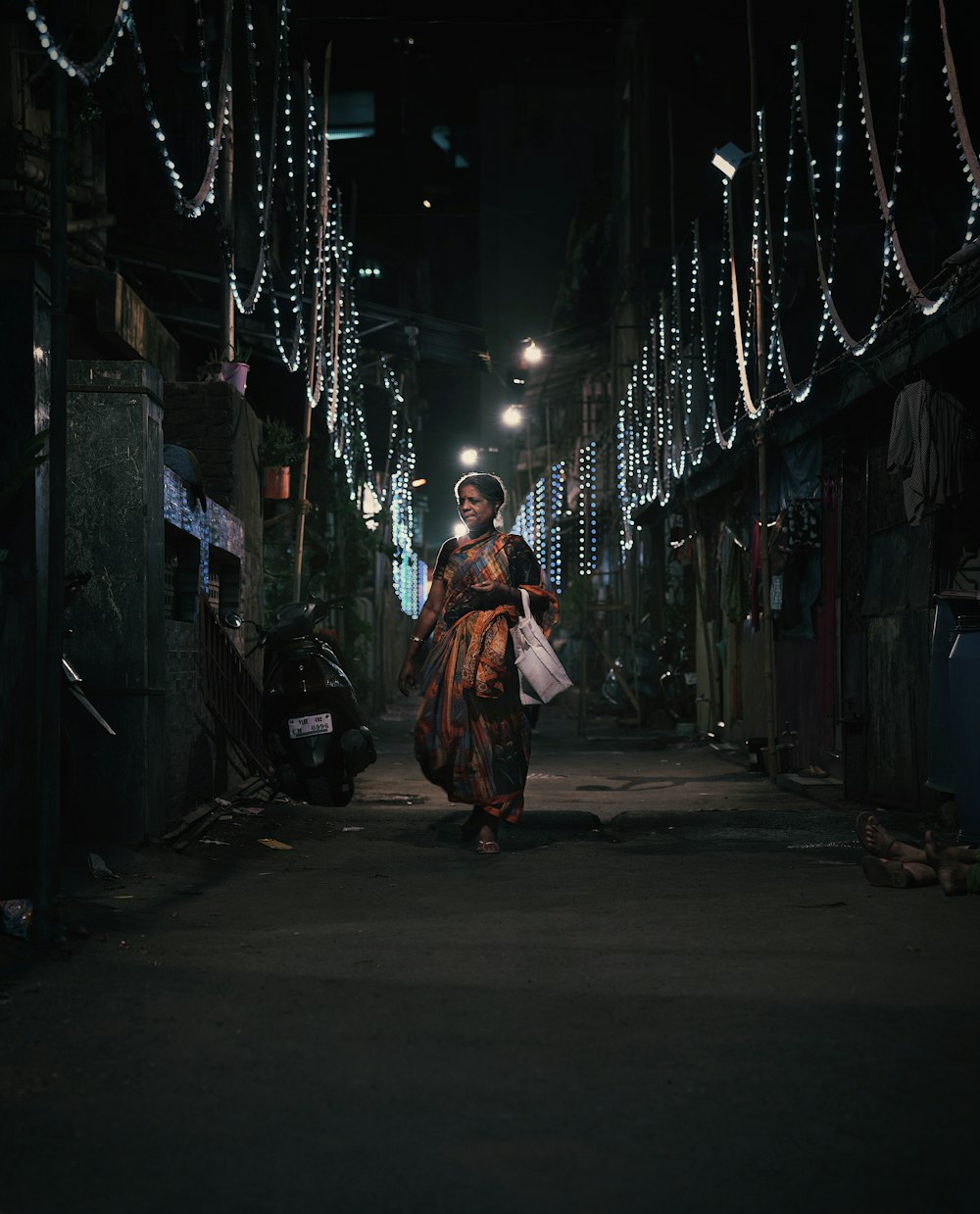 a woman walking down a street at night