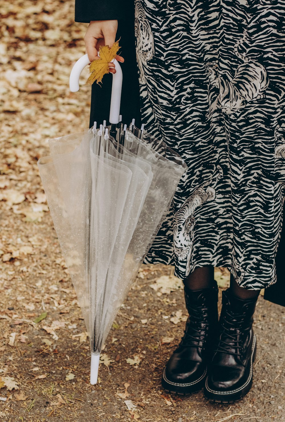 a person holding a clear umbrella on the ground