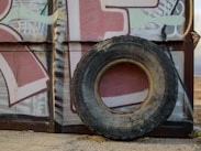 an old tire sitting on the side of a building