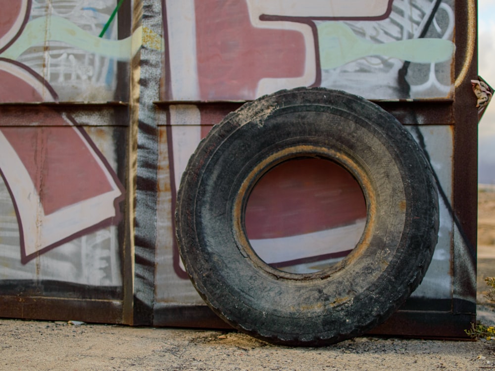 an old tire sitting on the side of a building