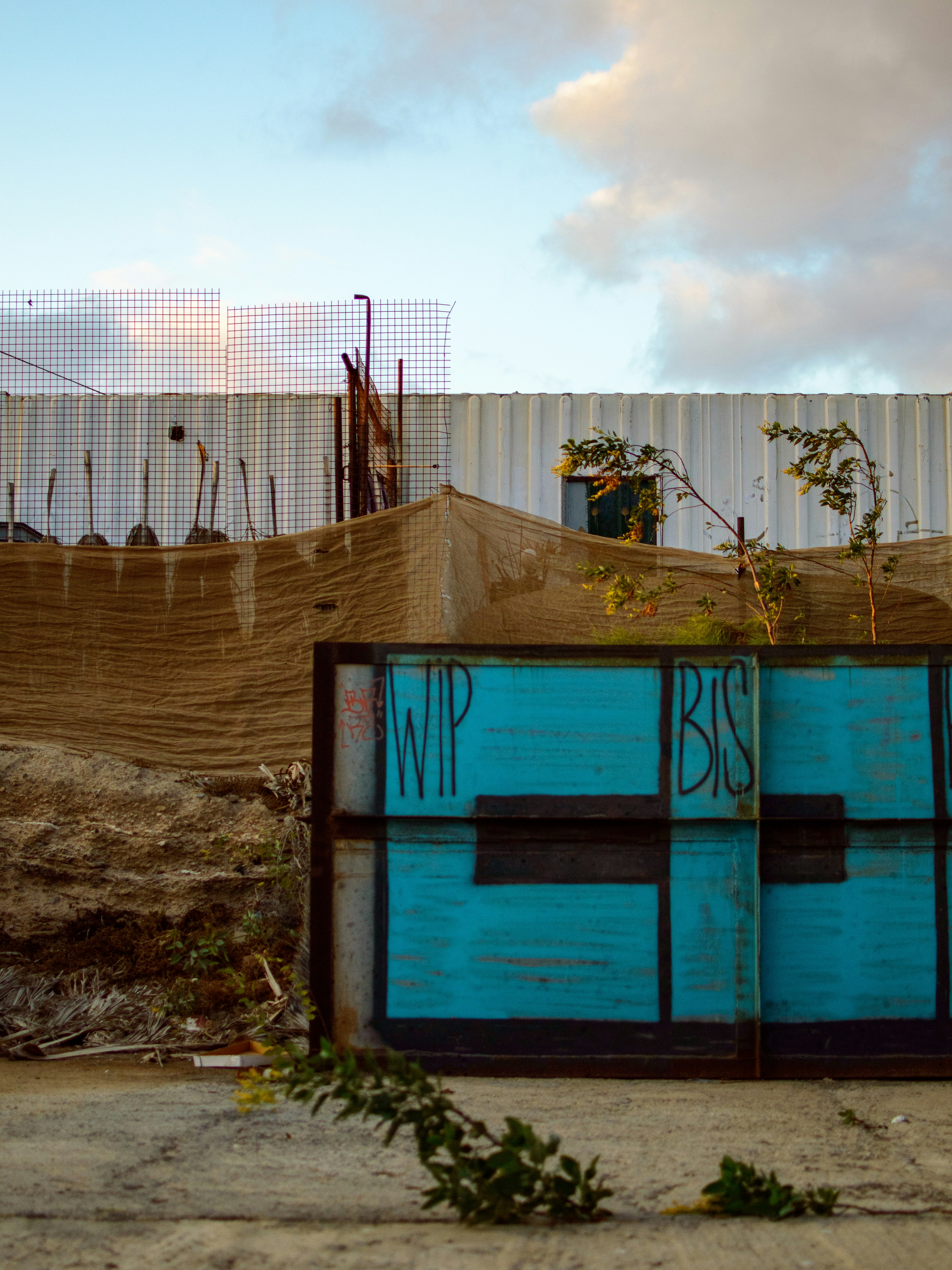 a blue box sitting in the middle of a dirt field