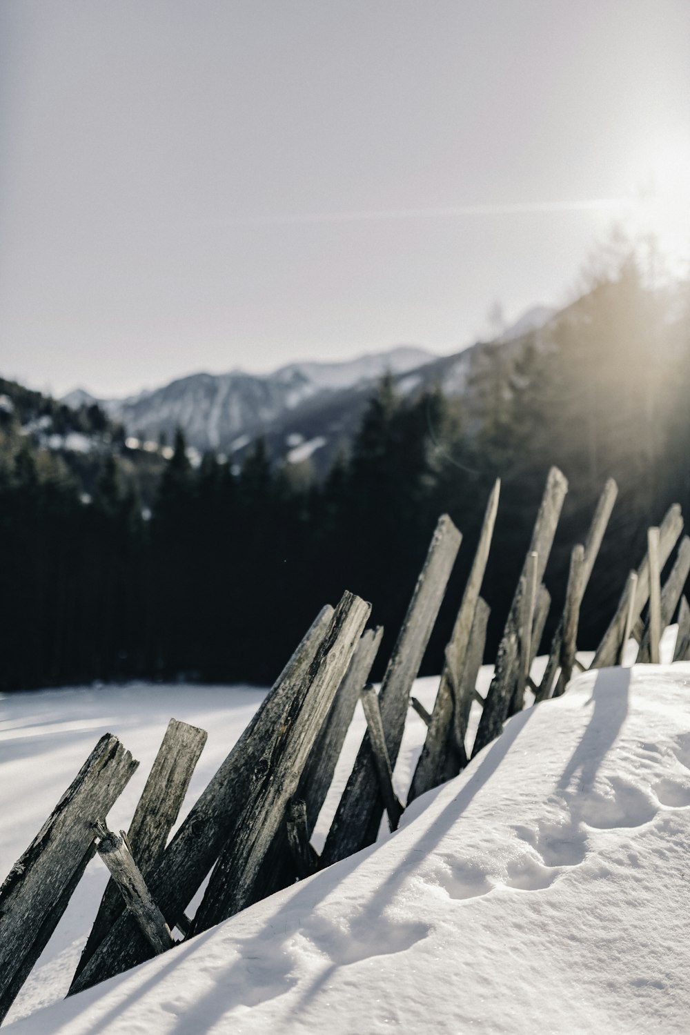 a wooden fence sitting on top of a snow covered slope