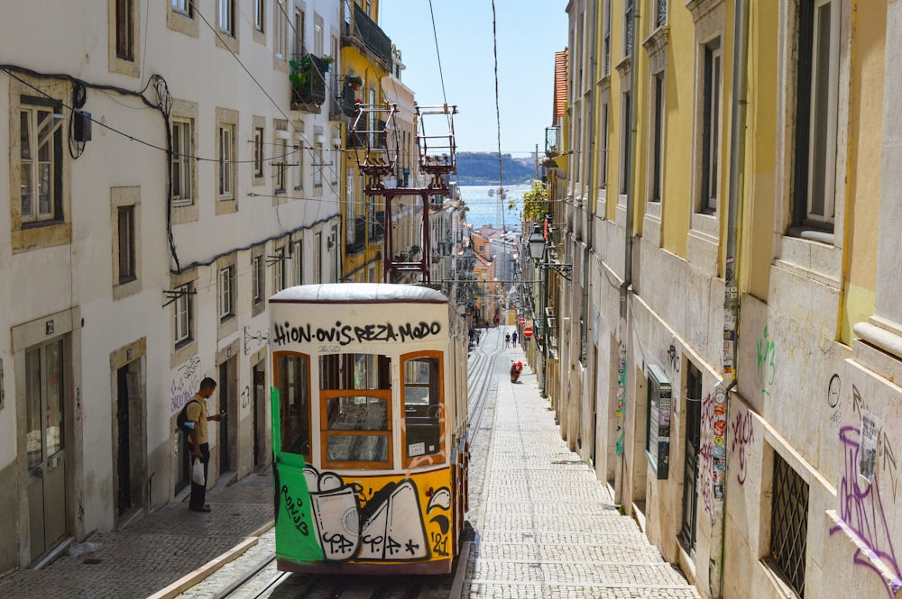 a trolley car on a narrow street in a city