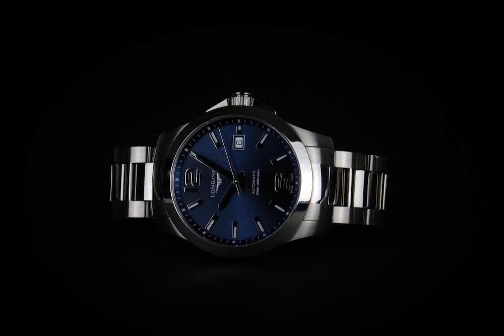a watch with a blue dial on a black background