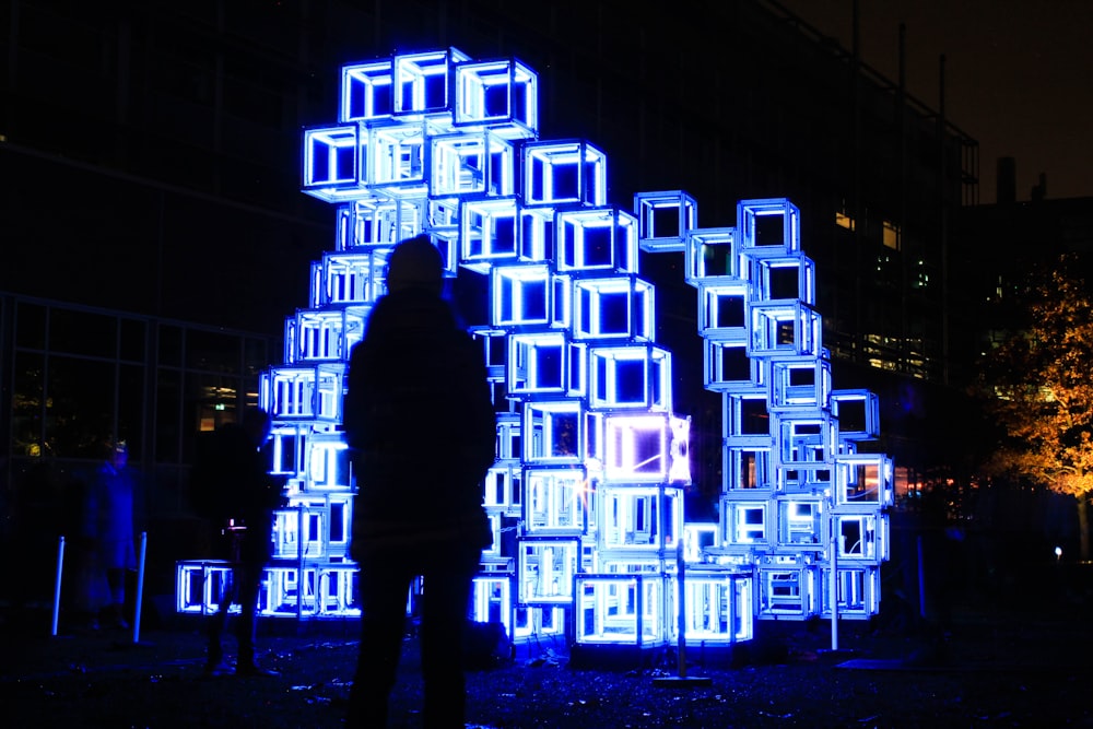 a person standing in front of a blue sculpture