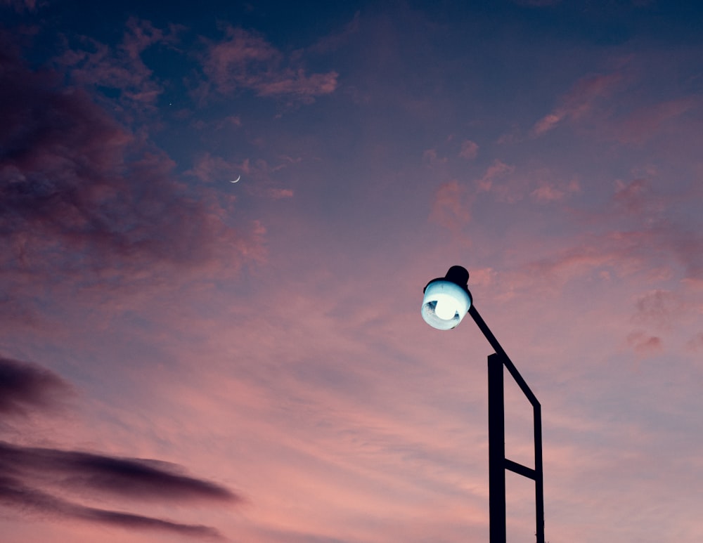 a street light with a cloudy sky in the background