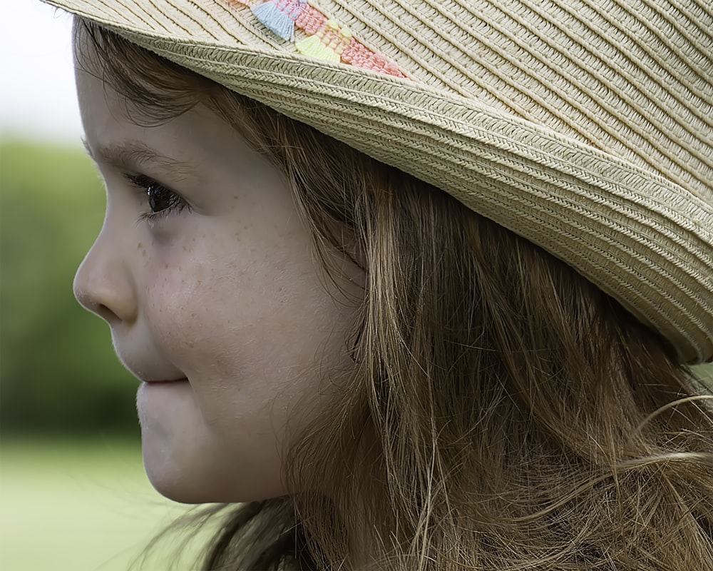 ein kleines Mädchen mit einem Hut auf dem Kopf