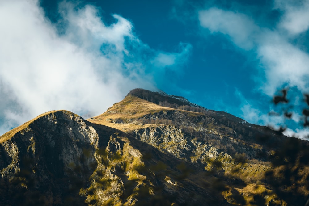 a very tall mountain with some clouds in the sky